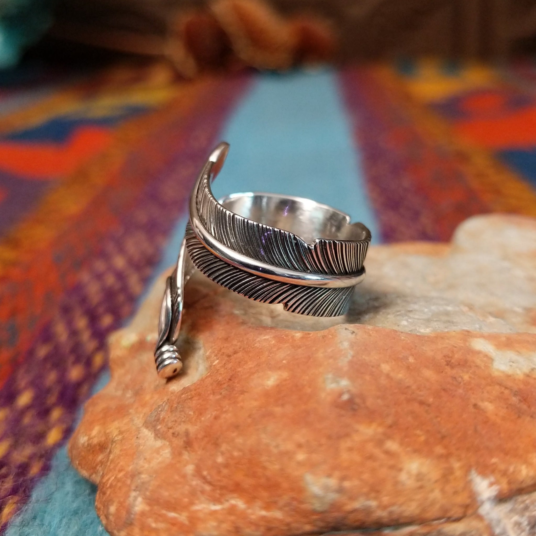 Wrapped silver feather ring by Lena Platero with detailed linework and overlapping design.