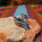 Wrapped silver feather ring by Lena Platero with detailed linework and overlapping design.