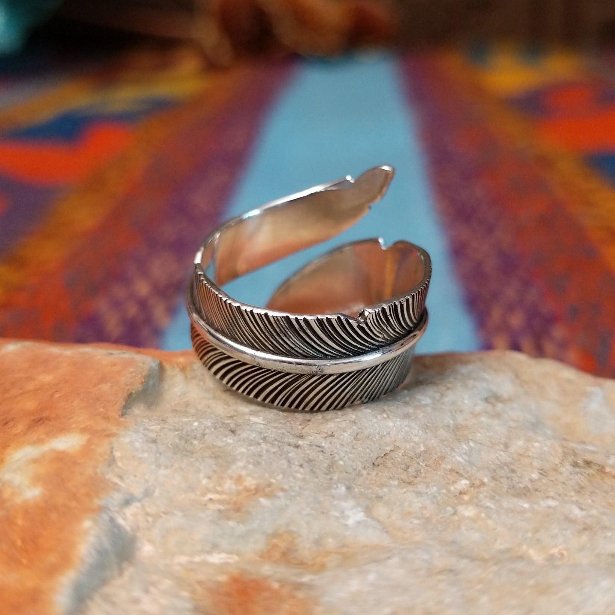Wrapped silver feather ring by Lena Platero with detailed linework and overlapping design.