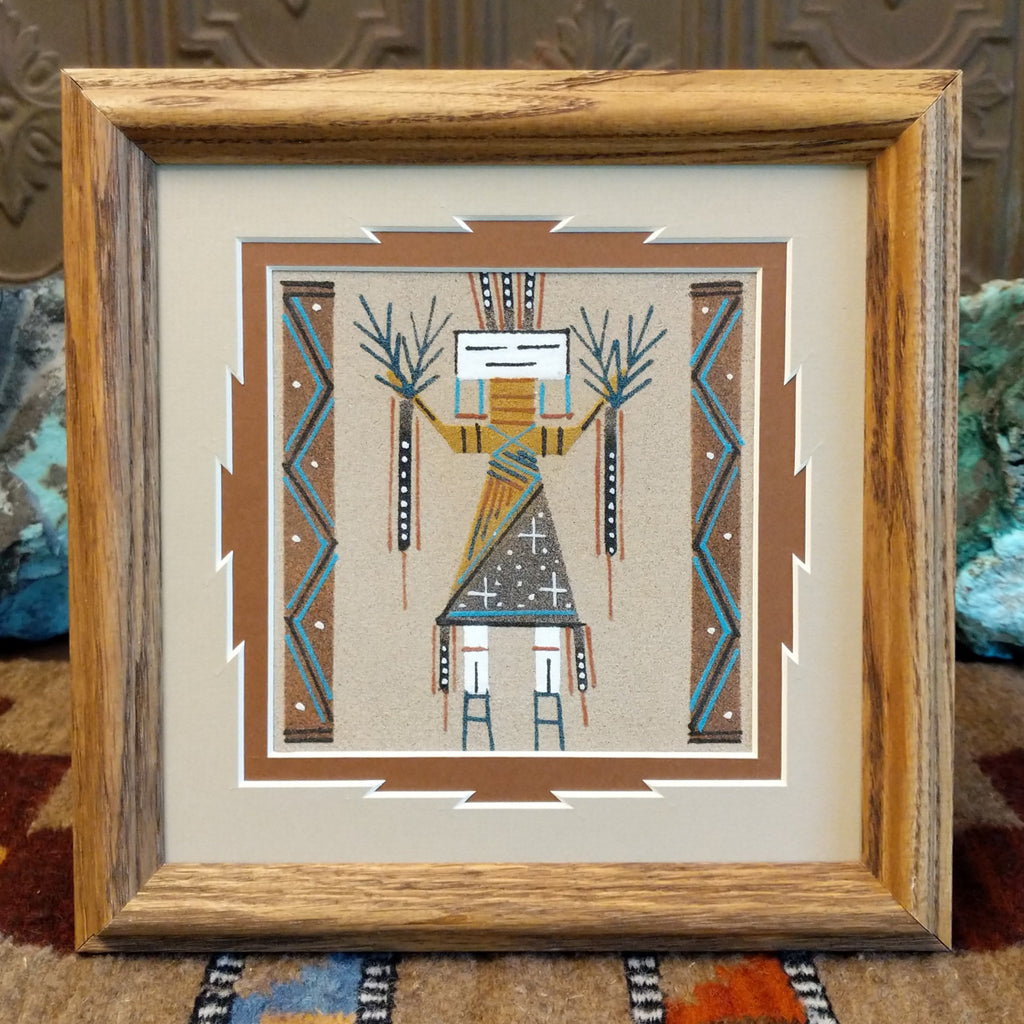 Yei created multicolored sand set within a wooden frame.