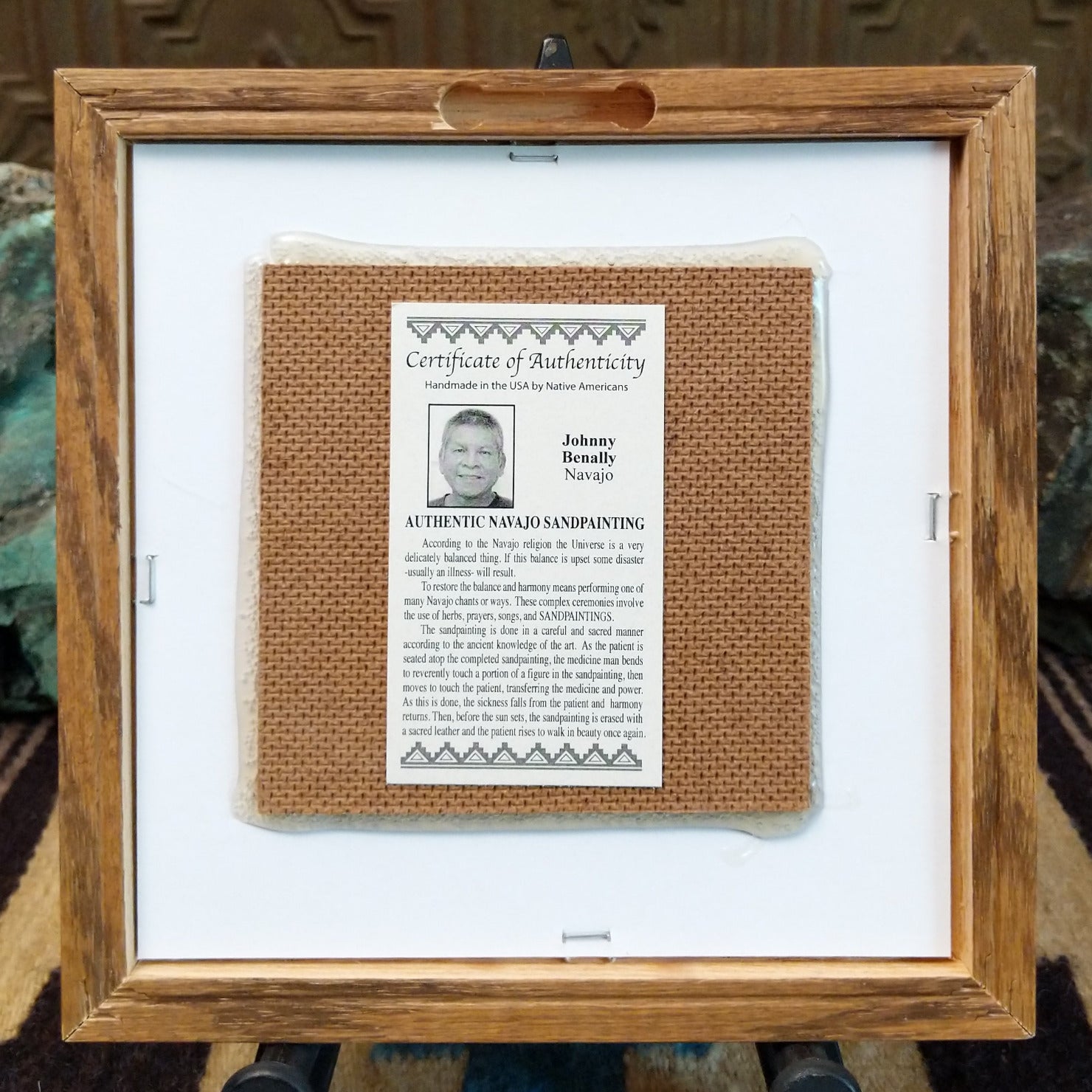 Backside of the Yei sand painting, showing the Certificate of Authenticity and Artist information. 