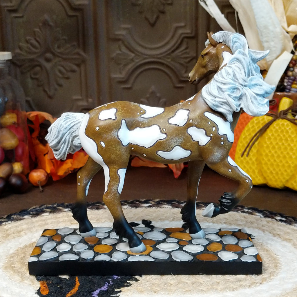 Resin pony painted in brown and white accents sat on a painted pebble base.