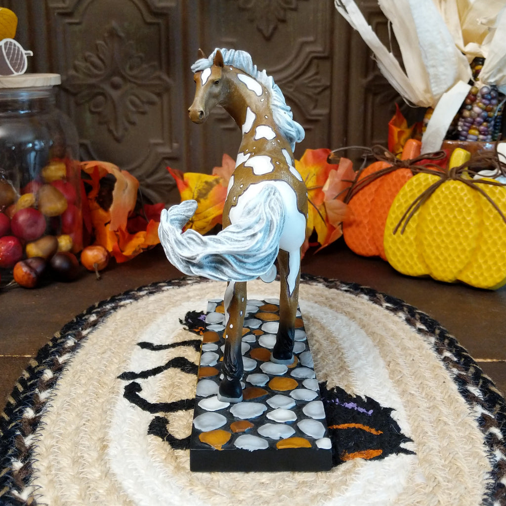 Resin pony painted in brown and white accents sat on a painted pebble base.