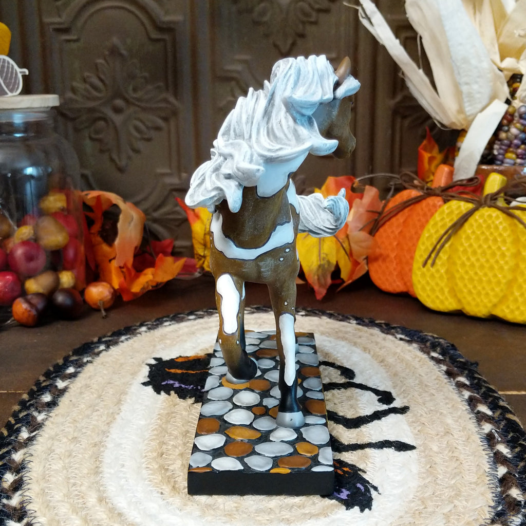 Resin pony painted in brown and white accents sat on a painted pebble base.