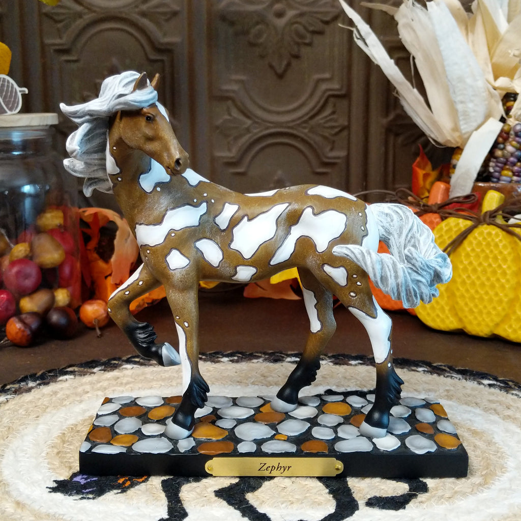Resin pony painted in brown and white accents sat on a painted pebble base.