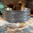 Wide sterling silver cuff bracelet with twin zigzag bands and intricate hand-stamped geometric detailing.