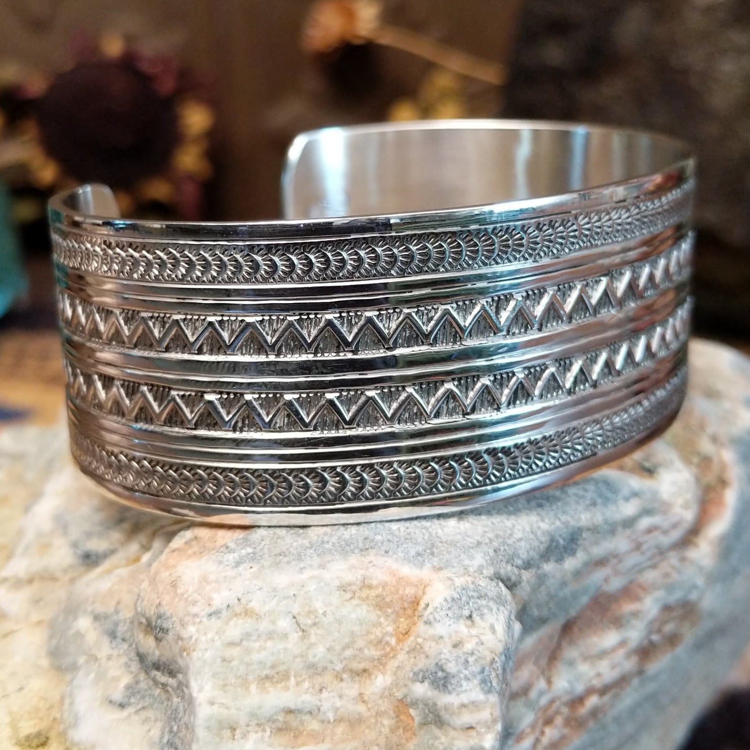 Wide sterling silver cuff bracelet with twin zigzag bands and intricate hand-stamped geometric detailing.
