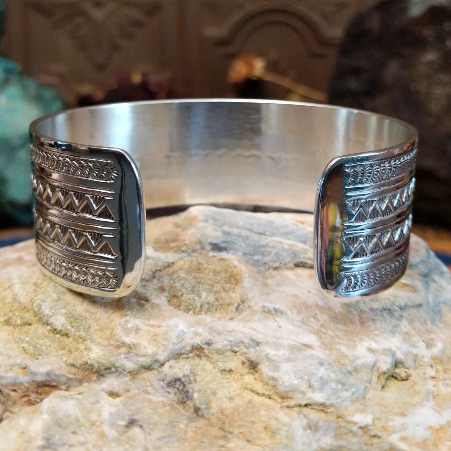 Wide sterling silver cuff bracelet with twin zigzag bands and intricate hand-stamped geometric detailing.