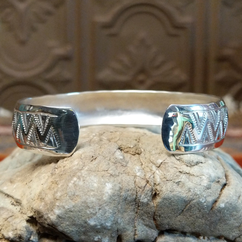 Sterling silver cuff with zigzag patterns on the surface.