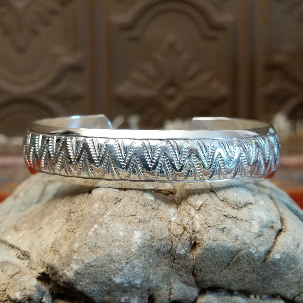 Sterling silver cuff with zigzag patterns on the surface.