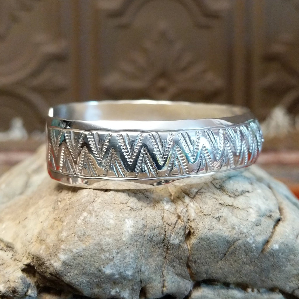 Sterling silver cuff with zigzag patterns on the surface.