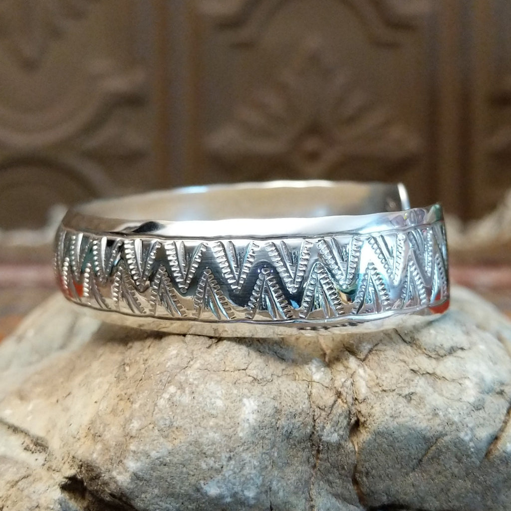 Sterling silver cuff with zigzag patterns on the surface.