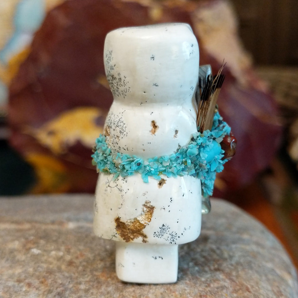 Serpentine carved into an altar doll fetish holding feathers, and turquoise clusters looping around the body.