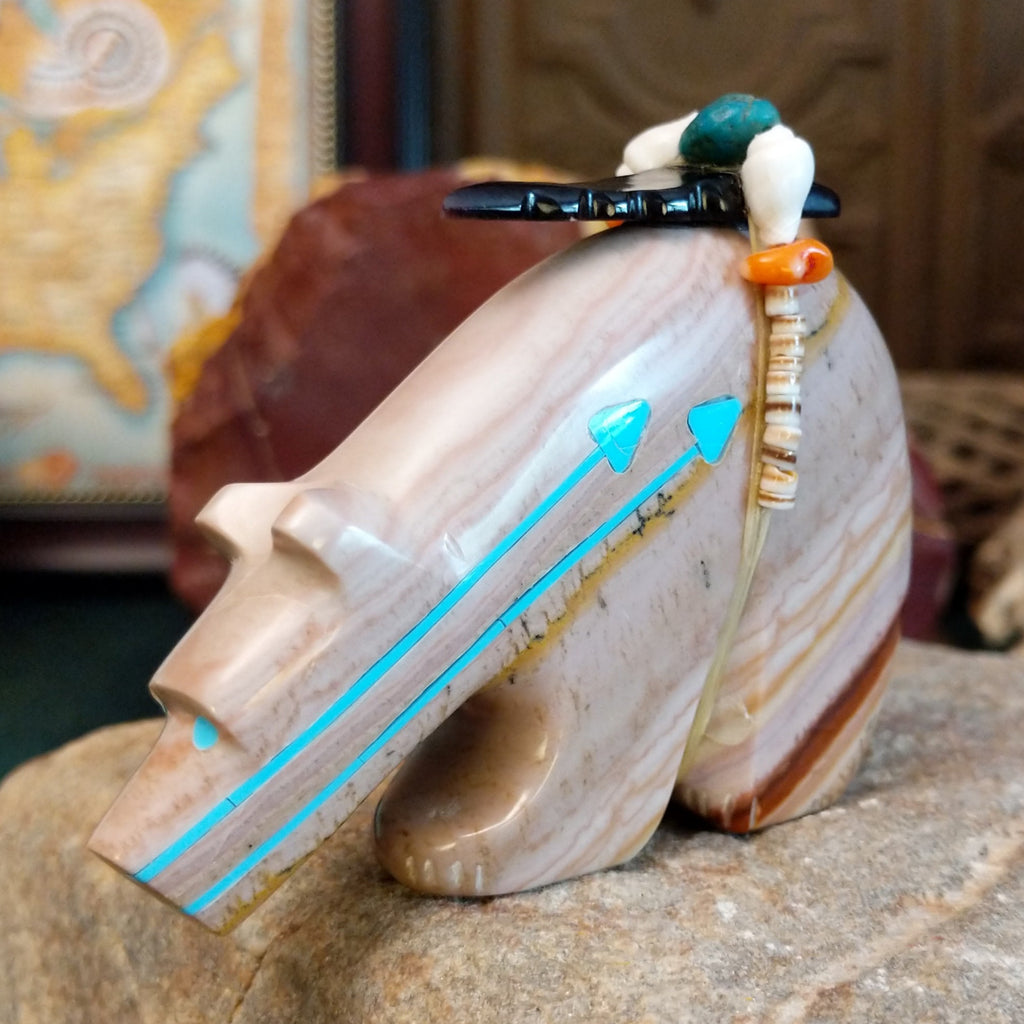 Banded dolomite carved into a bear with turquoise arrows inlaid on the body and pen shell and various stones beaded along its' torso.