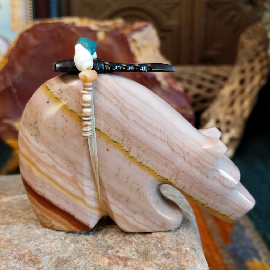Banded dolomite carved into a bear with turquoise arrows inlaid on the body and pen shell and various stones beaded along its' torso.