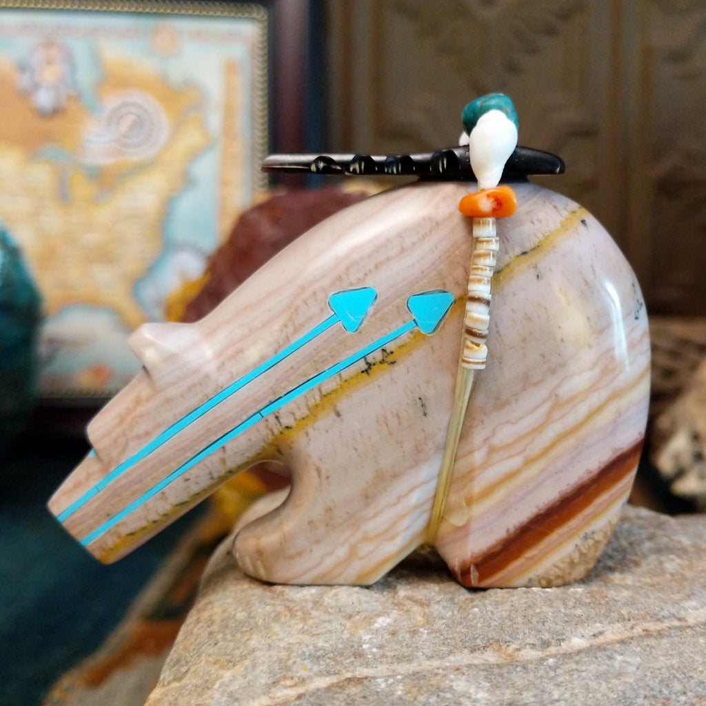 Banded dolomite carved into a bear with turquoise arrows inlaid on the body and pen shell and various stones beaded along its' torso.