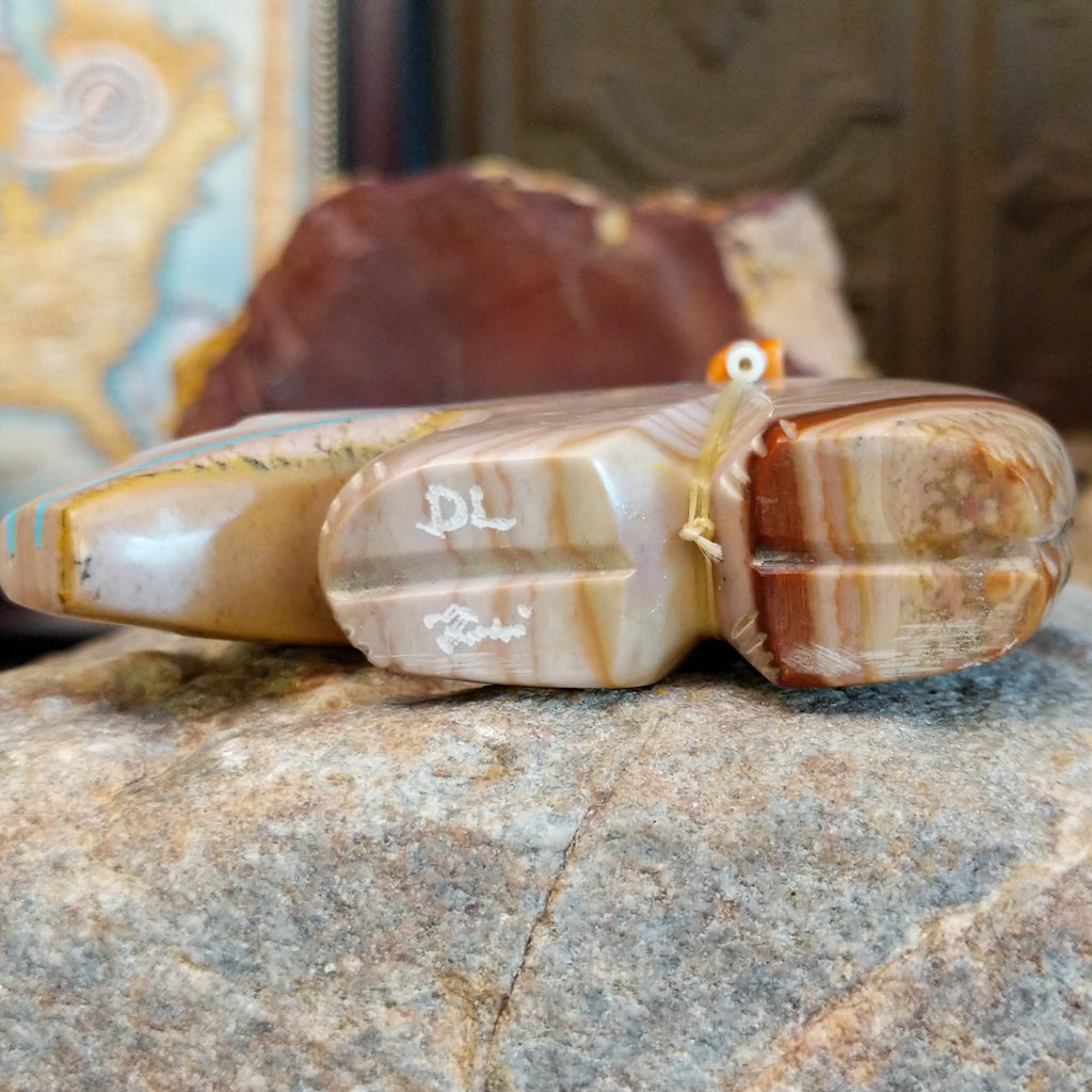 The artisan's signature is etched onto the bottom of the piece.