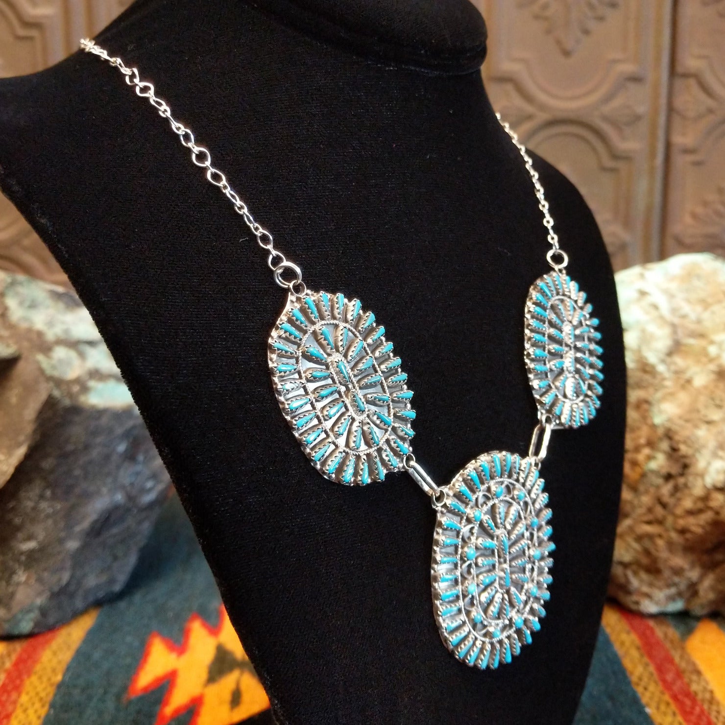 Sterling silver necklace with needlepoint clusters set on three conchos, and the turquoise set in notched bezels.