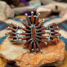 Handcrafted Zuni sterling silver cuff by G.E. featuring coral needlepoint stones in a traditional concho design with silver bead accents and a triple-shank cuff.