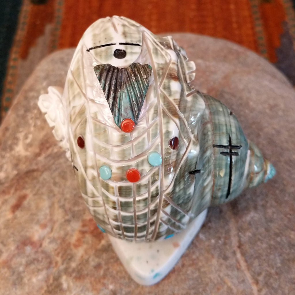 Green snail shell carved as a corn maiden along the shell with small turquoise beads.