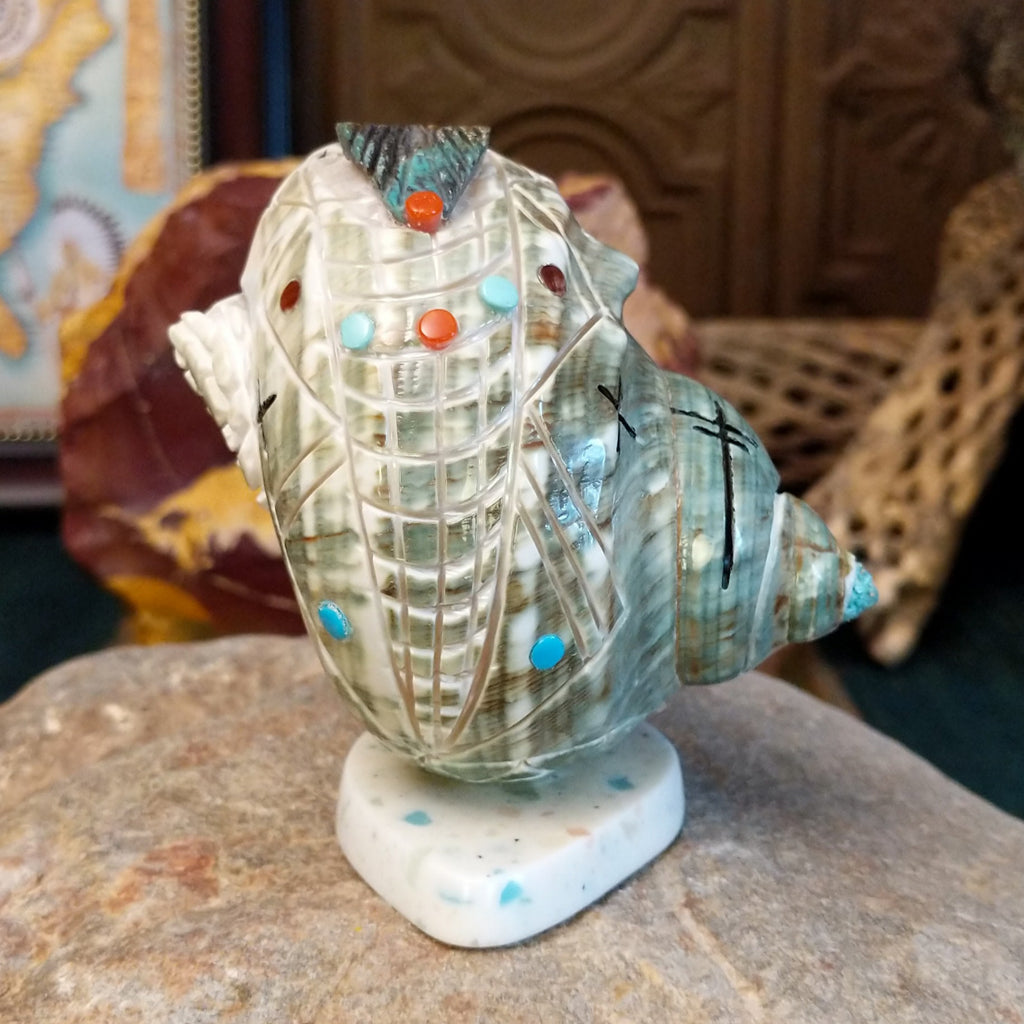 Green snail shell carved as a corn maiden along the shell with small turquoise beads.