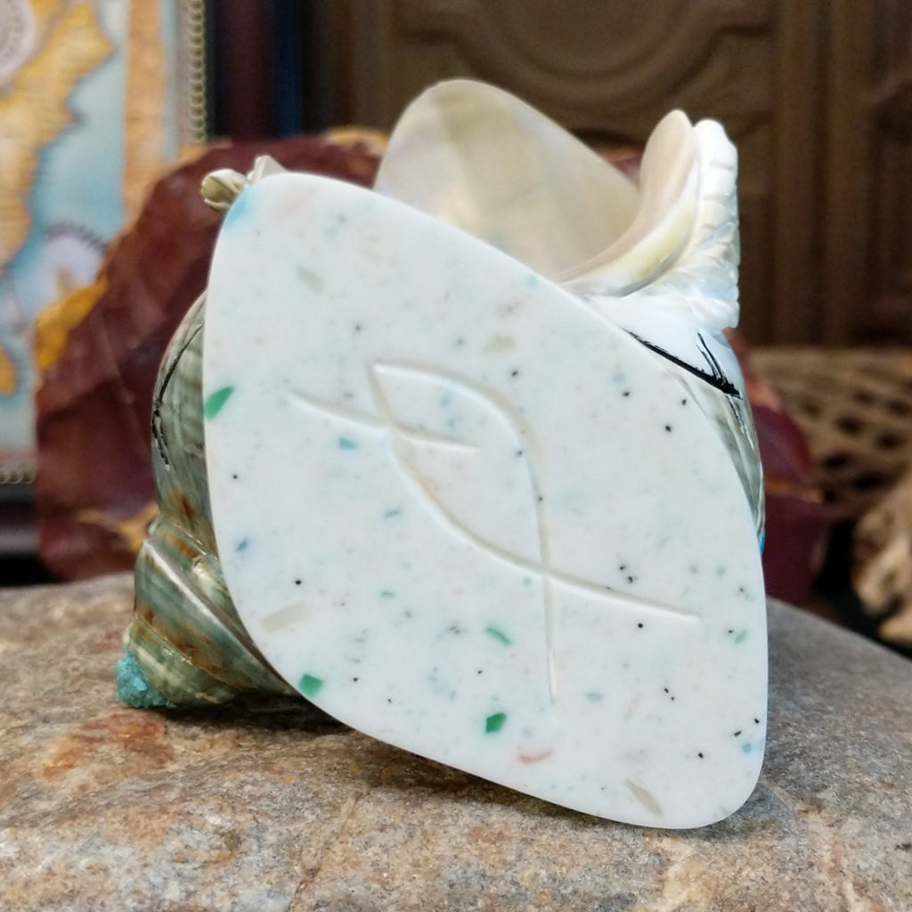 The artisan's signature is found at the bottom of the shell.