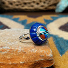 Handcrafted sterling silver Zuni dome ring by Lee & Mary Weebothee, featuring a colorful Sunface-inspired multistone inlay surrounded by lapis; side view.