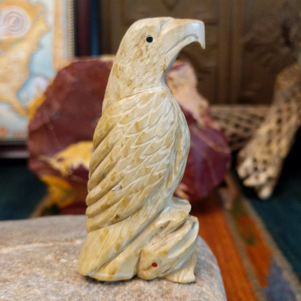Alabaster carved into an eagle fetish with intricate detailing and a rabbit caught in its' talons.