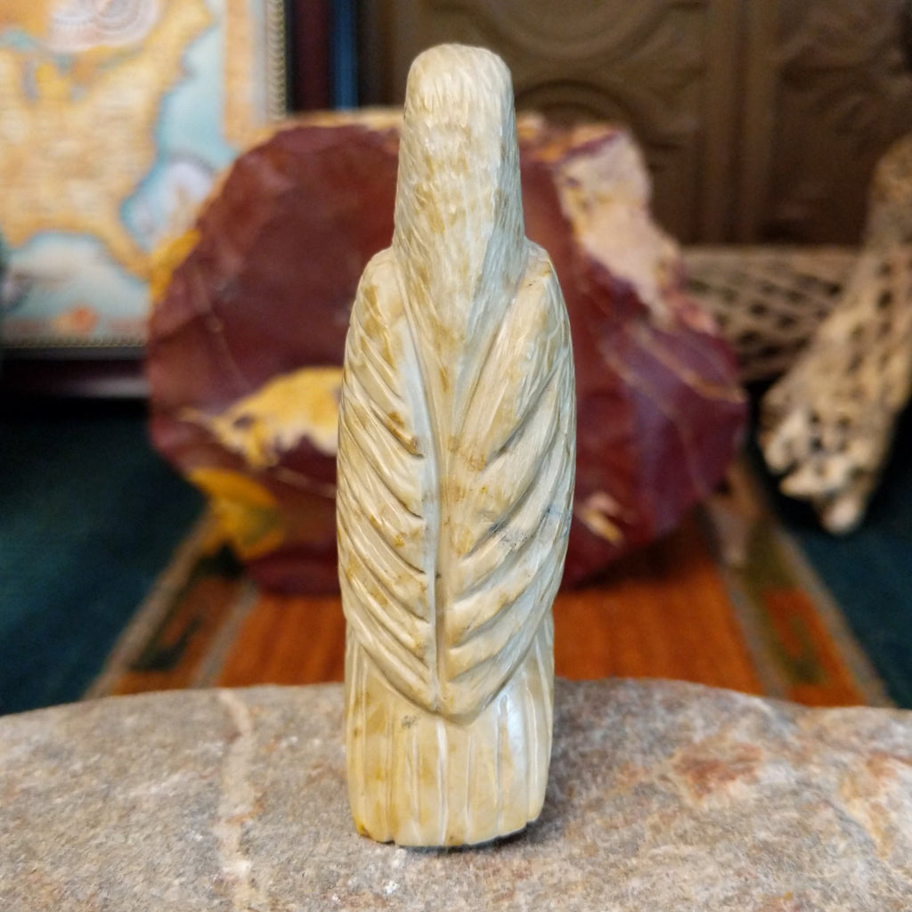 Alabaster carved into an eagle fetish with intricate detailing and a rabbit caught in its' talons.