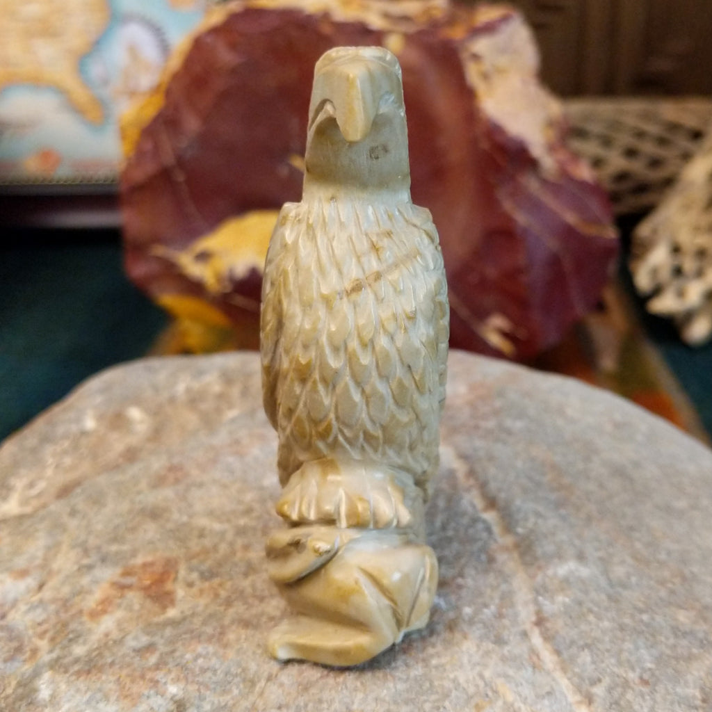 Alabaster carved into an eagle fetish with intricate detailing and a rabbit caught in its' talons.