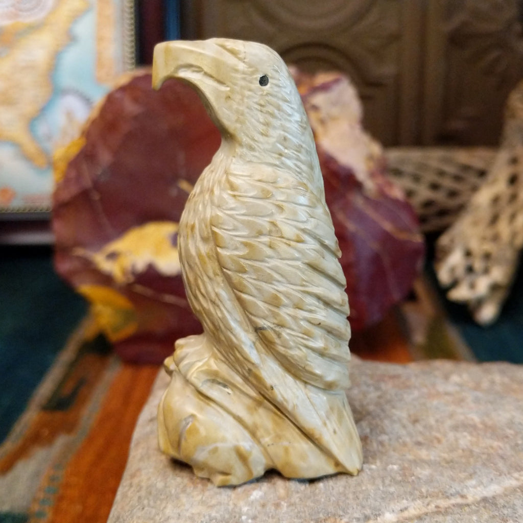 Alabaster carved into an eagle fetish with intricate detailing and a rabbit caught in its' talons.