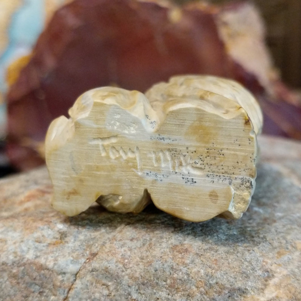 The artisan's signature is etched onto the bottom of the piece.