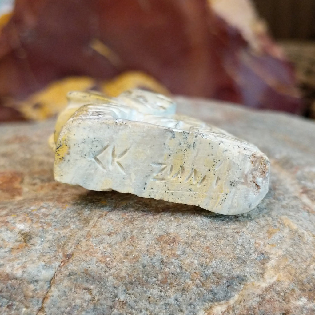 The artisan's signature is found at the bottom of the piece.