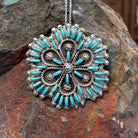 Zuni flowery needlepoint turquoise pendant and pin by Leekity featuring slender turquoise stones, twisted silver wire floral patterns, and decorative silver bead accents.