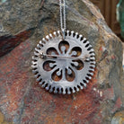 Zuni needlepoint turquoise pendant and pin by Vincent Johnson featuring slender turquoise stones arranged around a circular silver frame with intricate twisted-wire floral details and silver accents; artisan stamp.