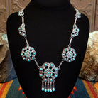 Sterling silver necklace with floral settings and turquoise set in the bezels.