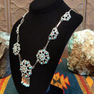 Sterling silver necklace with floral settings and turquoise set in the bezels.