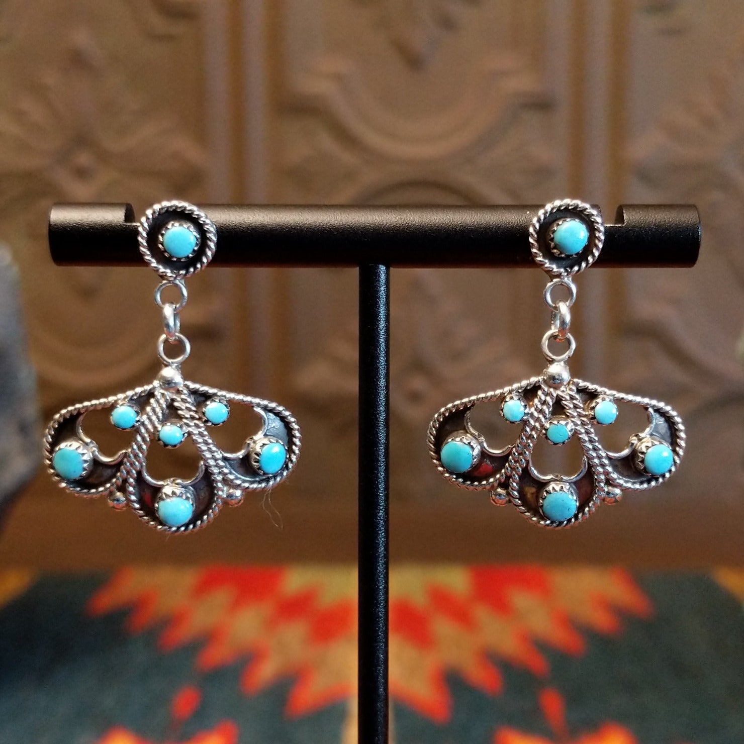Sterling silver earrings with floral settings and turquoise set in the bezels.