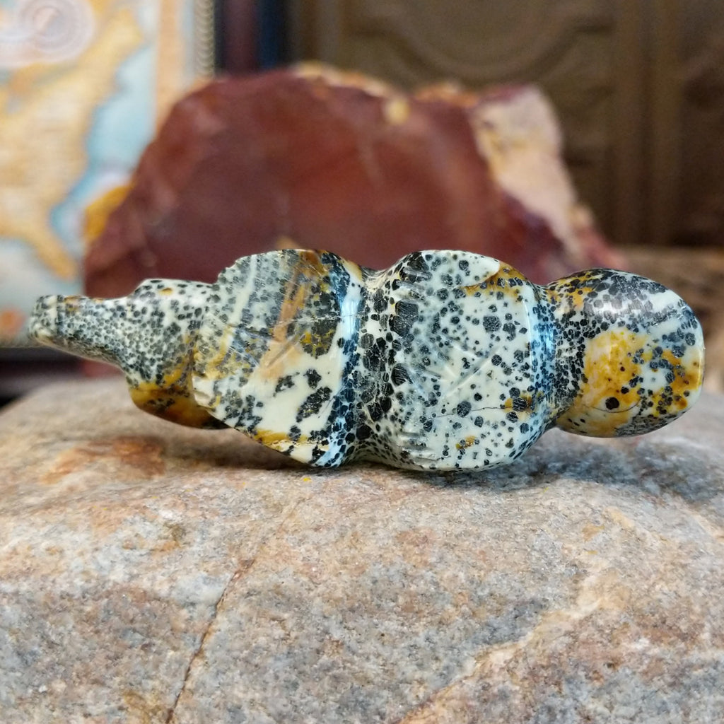 The artisan's signature is etched onto the bottom of the piece.