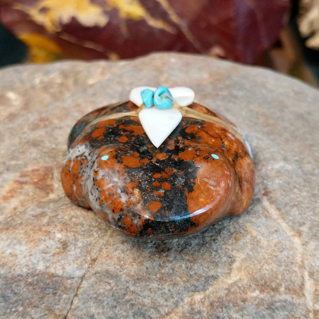 Brown and black matrix stone carved into a frog fetish with turquoise and mother of pearl tied to its' back.