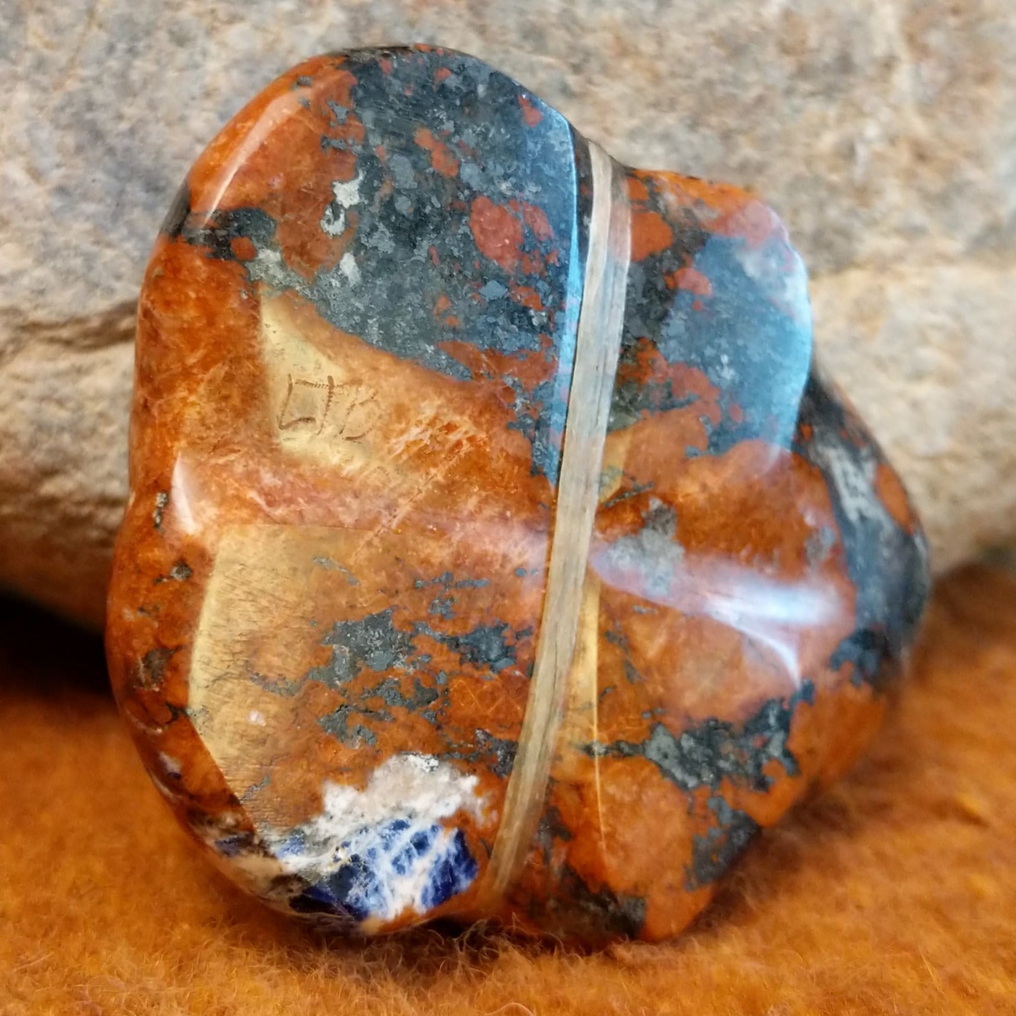 The artisan's initials are carved into the underside of the piece.