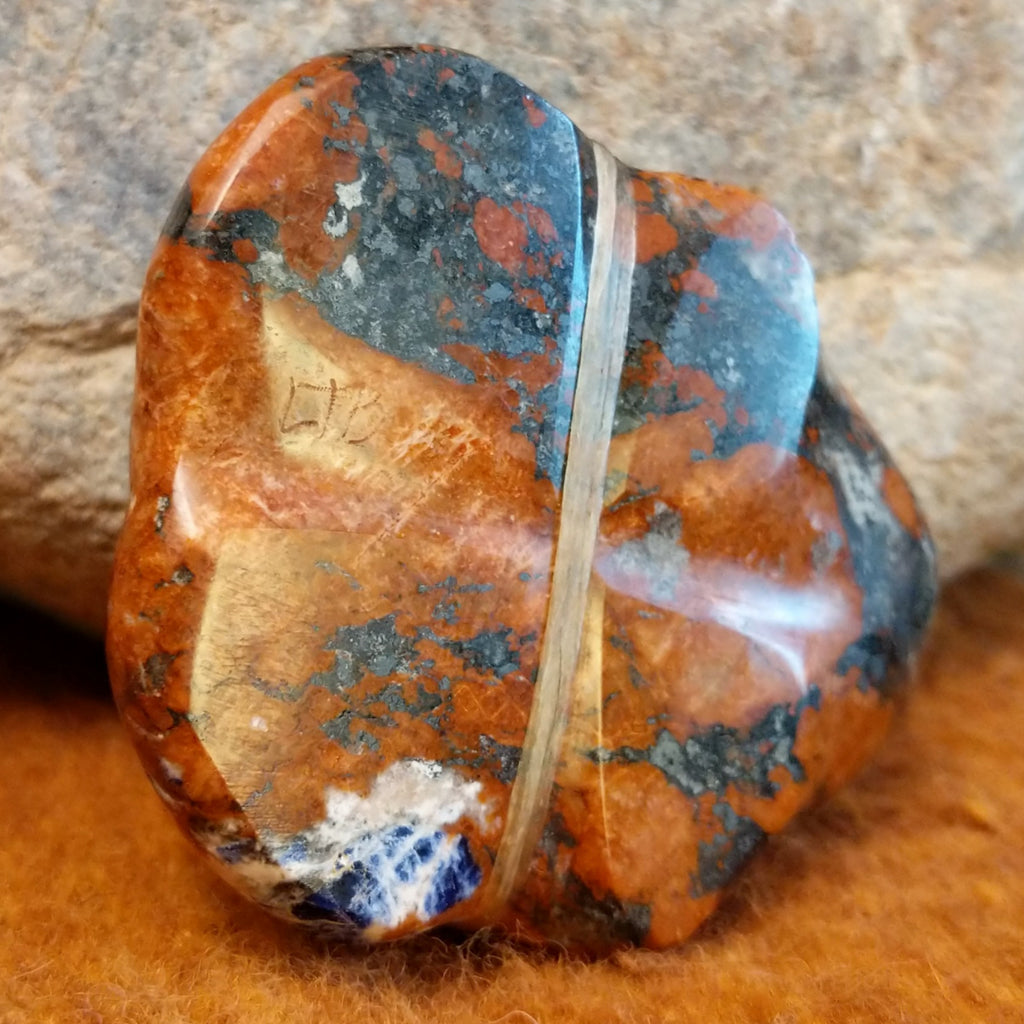 The artisan's initials are carved into the underside of the piece.