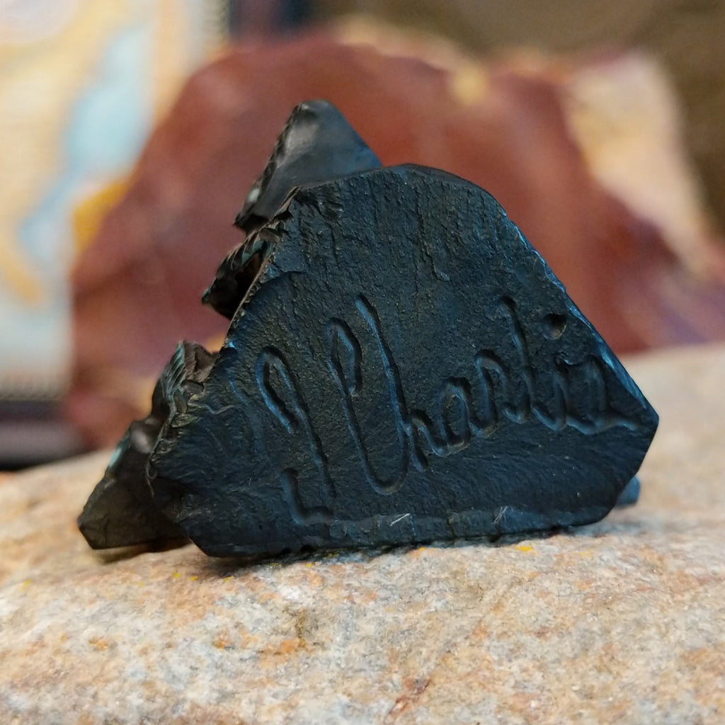 The artisan's signature is etched on the bottom of the fetish.