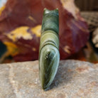 Ricolite carved into a horse fetish with green banding and etched details.