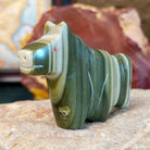 Ricolite carved into a horse fetish with green banding and etched details.