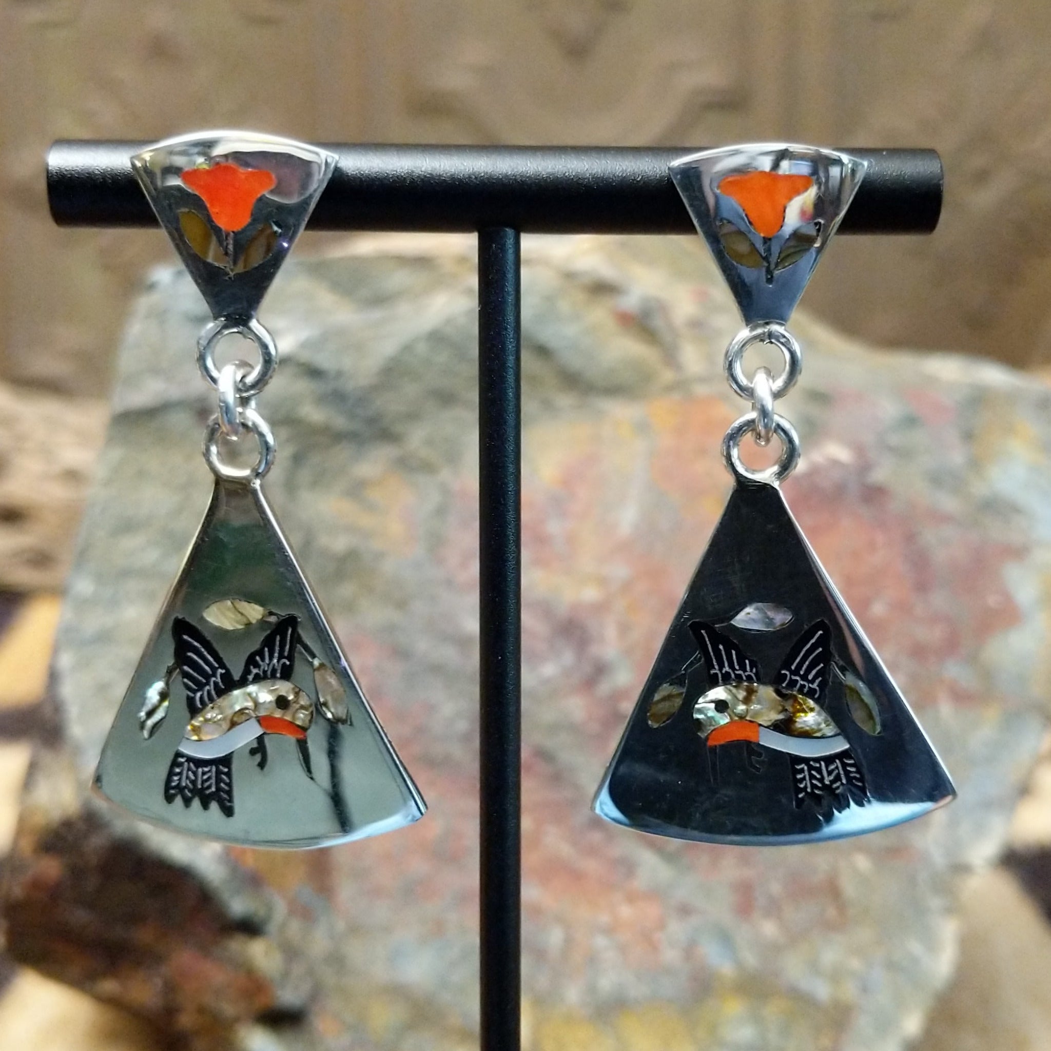 Handcrafted sterling silver Zuni hummingbird inlay earrings by Sanford Edaakie, featuring a two-piece dangle design with colorful flowers and hummingbirds.