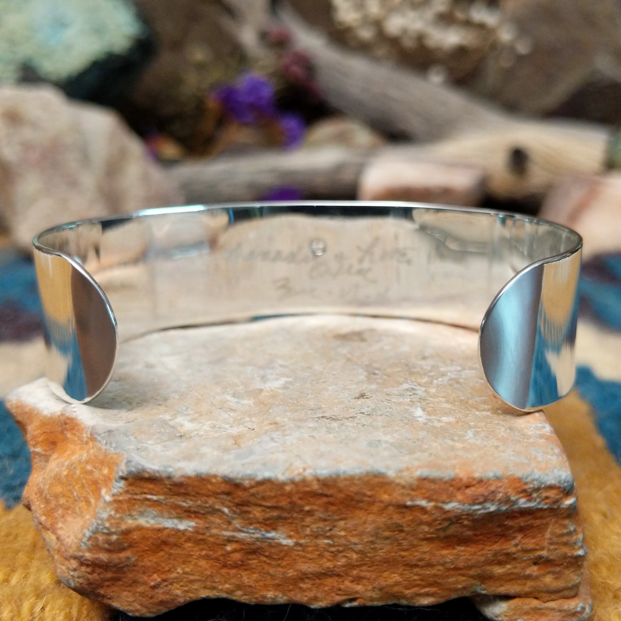 Handcrafted sterling silver Zuni cuff by Leander & Lisa Othole featuring a bold geometric channel inlay design with a polished sterling silver cuff and traditional Southwestern craftsmanship; underside view.