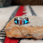 Zuni geometric inlay ring by Delberta Boone with turquoise, coral, shell, and dark stone.