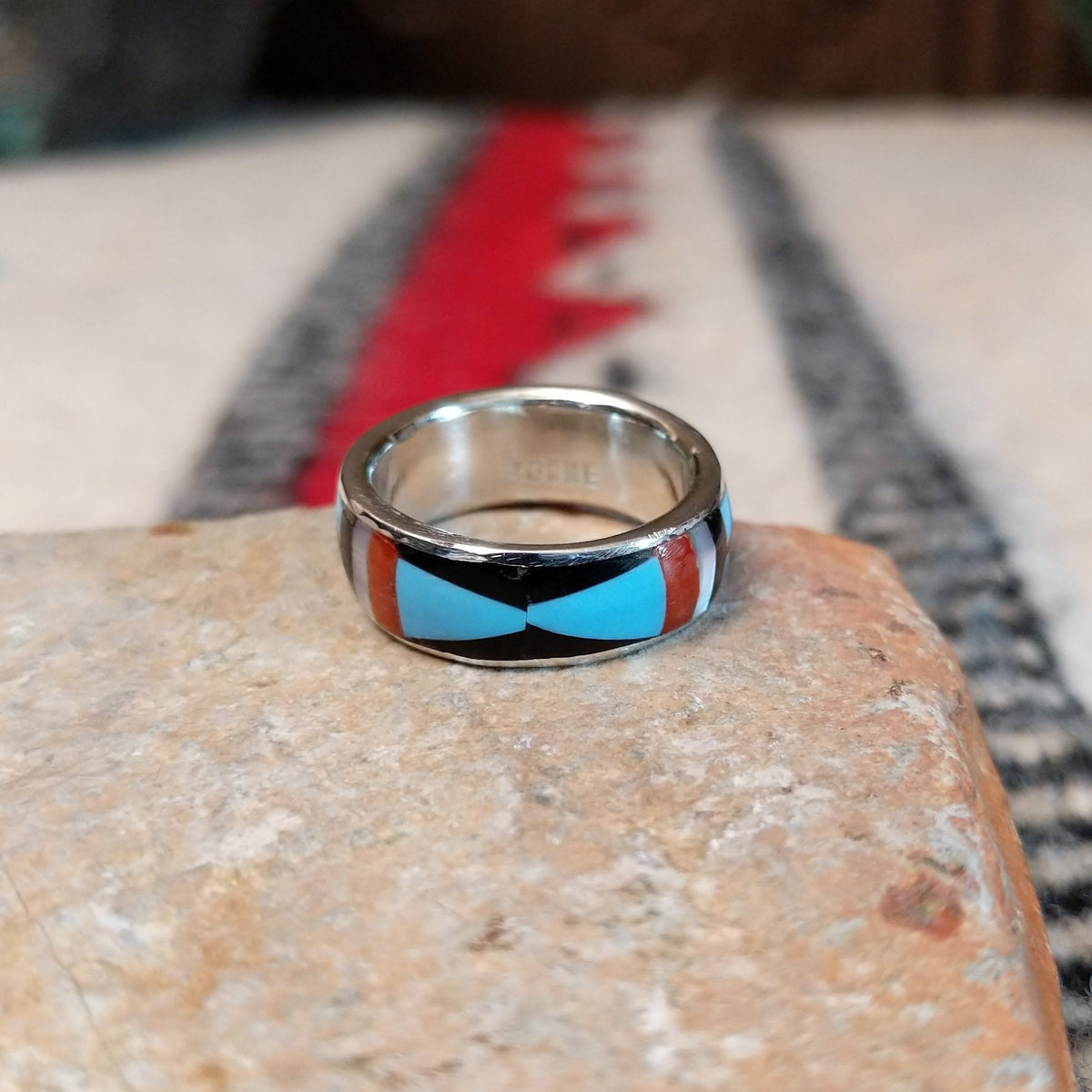 Zuni geometric inlay ring by Delberta Boone with turquoise, coral, shell, and dark stone.