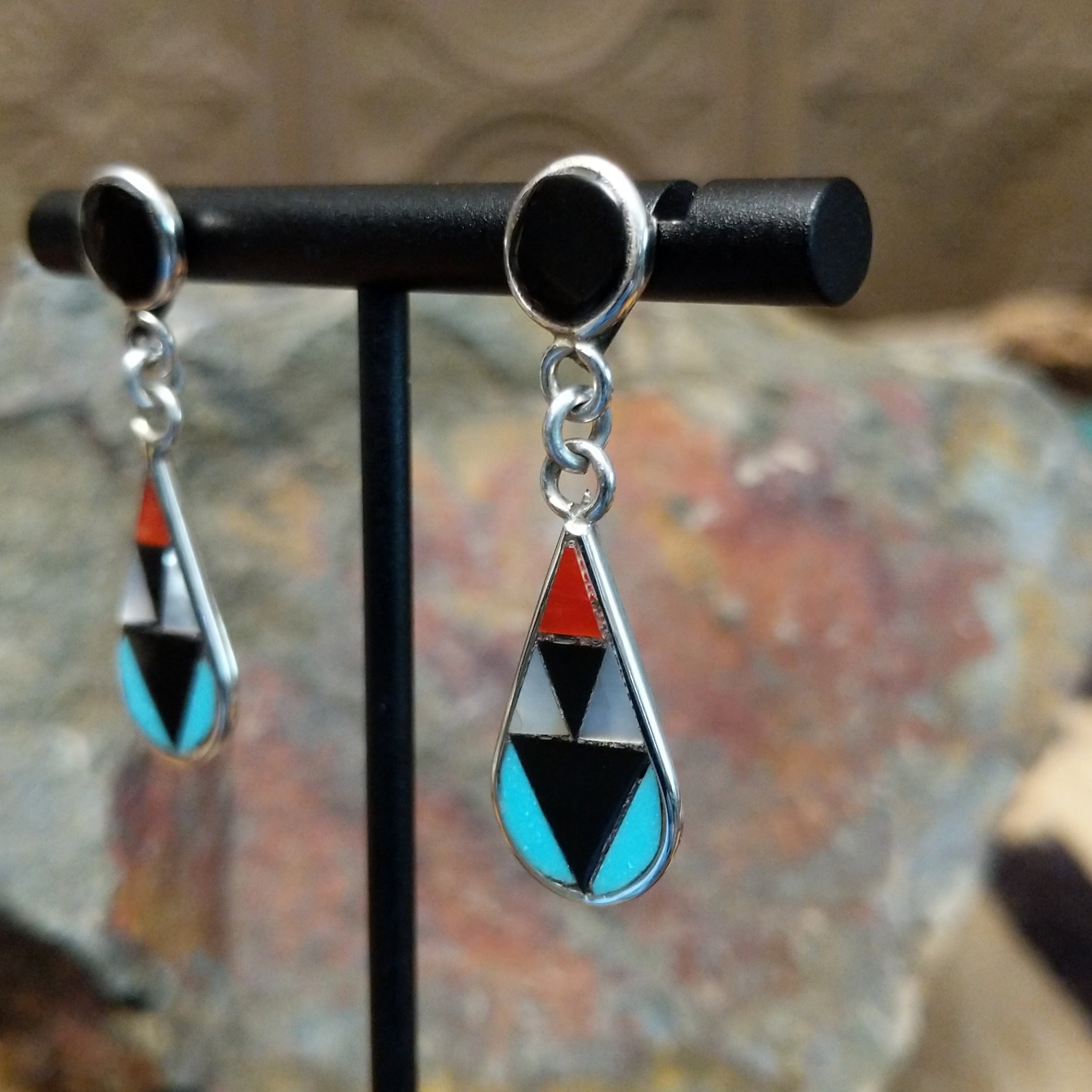 Handcrafted sterling silver Zuni inlay teardrop earrings by Florencia Lucio, featuring colorful multistone inlay in a classic teardrop design; side view.